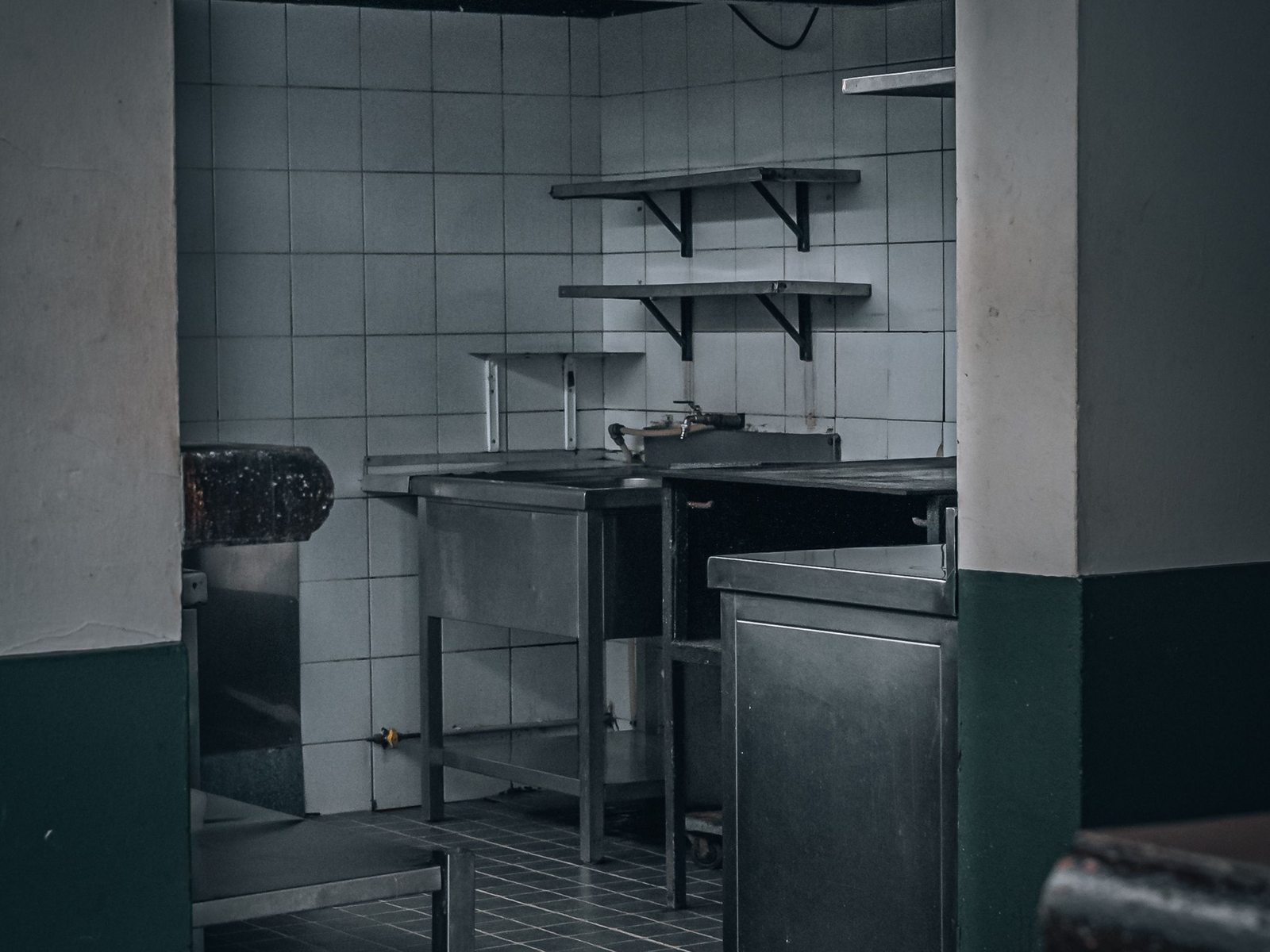 Empty commercial kitchen with stainless tables after closing