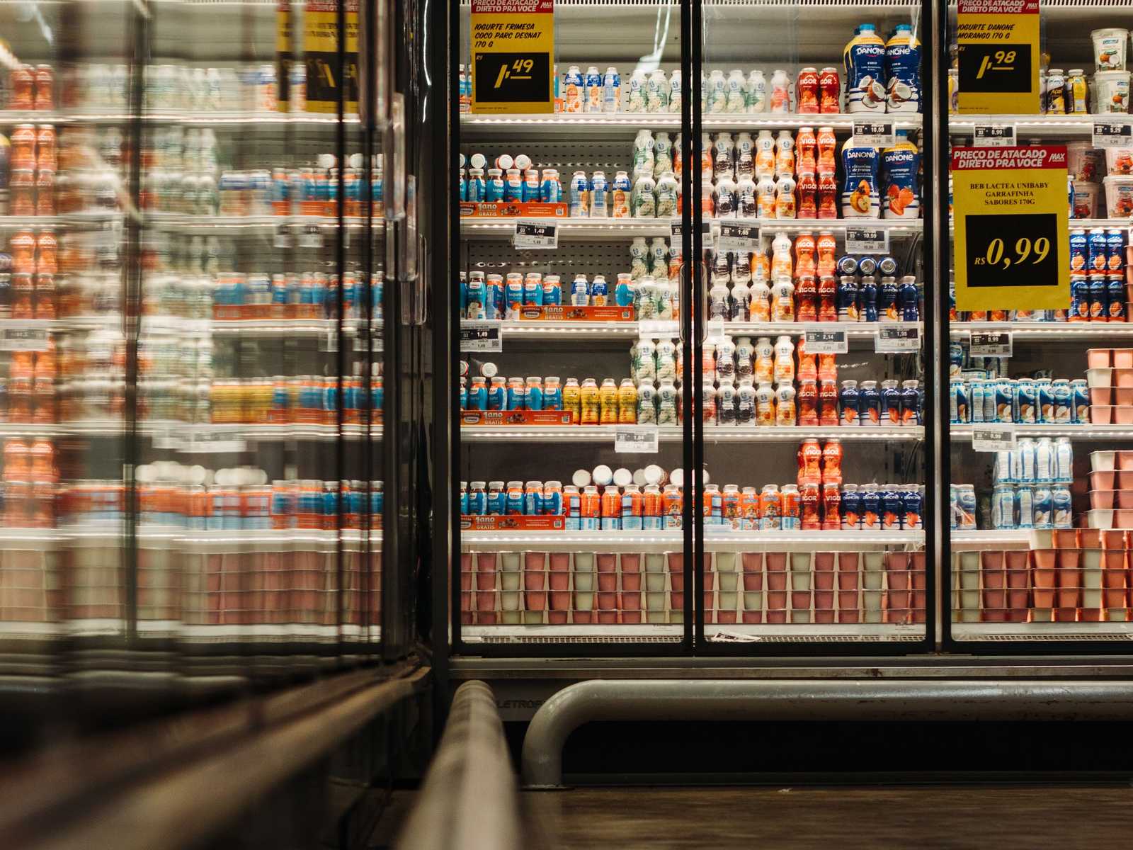 Aisle of glass door dairy coolers in a grocery store