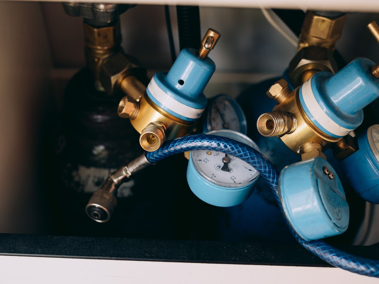 Pressure regulators and gauges with hoses attached