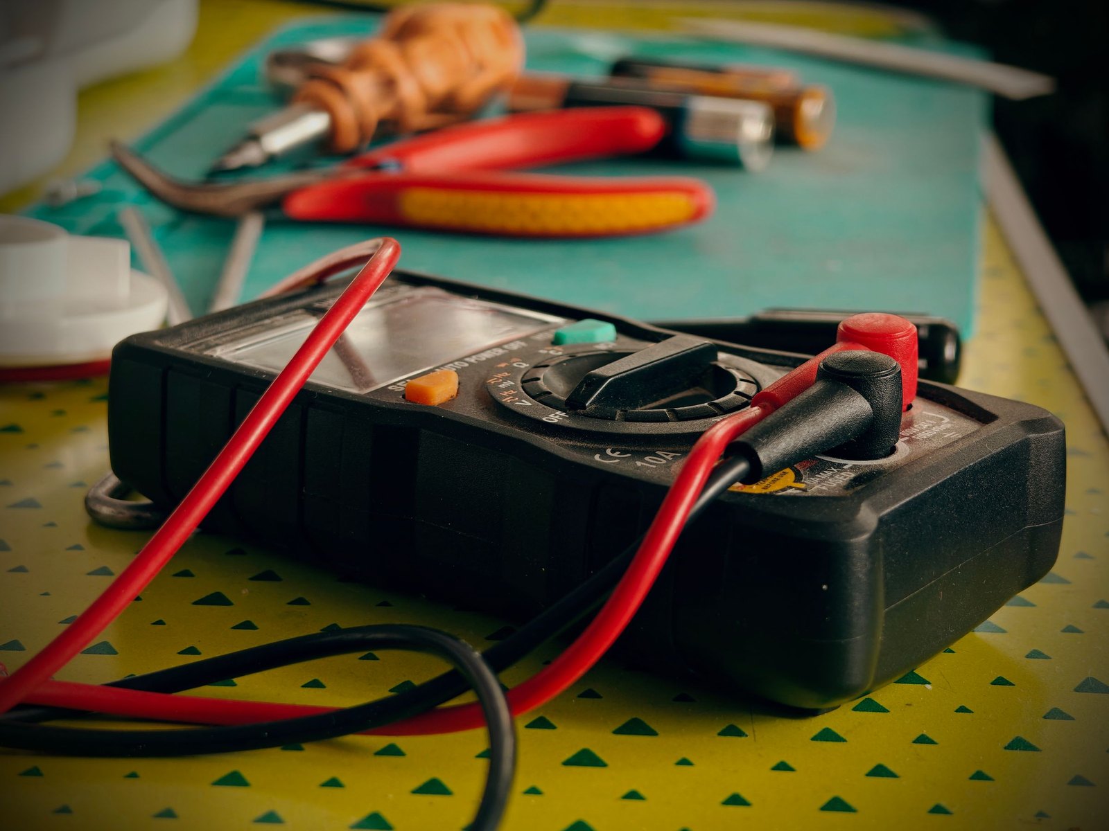 Multimeter and hand tools on a workbench