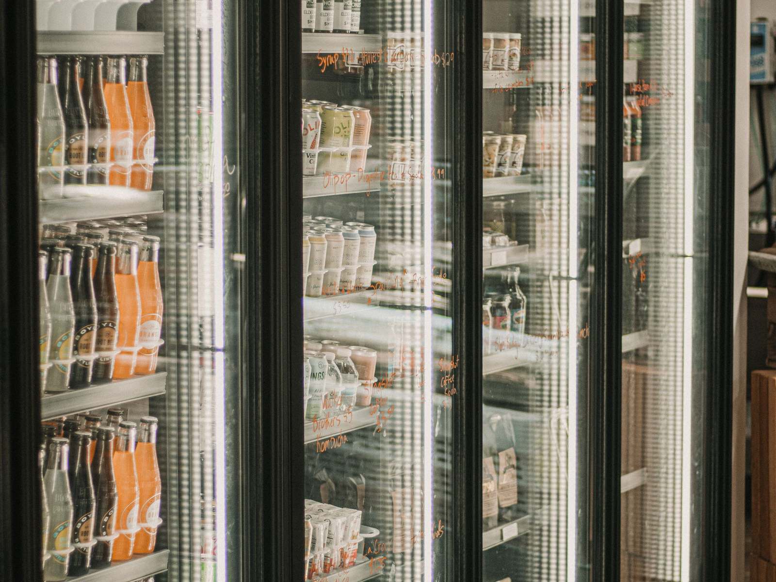 Row of glass door reach-in coolers stocked with bottled drinks